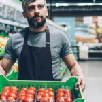A shopper checking ingredients, allergens, origin and pack size on a grocery product