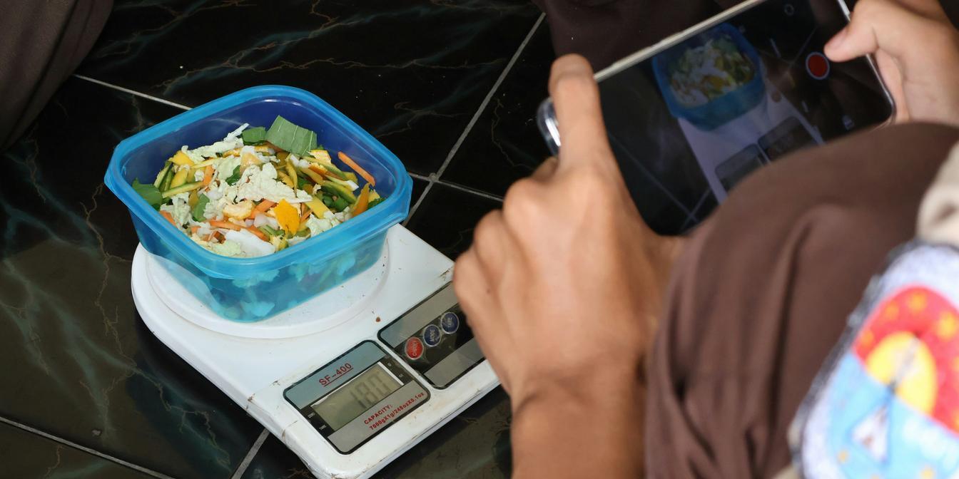 A portion of dried plums being measured by weight